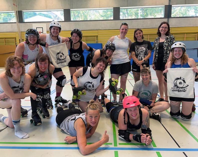 Ein Team-Bild vom Rolling Rat Pack in einer Regensburger Turnhalle. Dabei zeigen die Frauen Taschen mit dem Logo des Vereins.