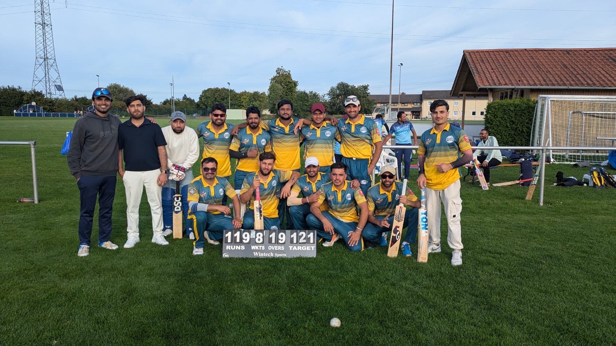 Das Männer-Cricket-Team steht auf dem Spielfeld in Mannschafts-Aufstellung.