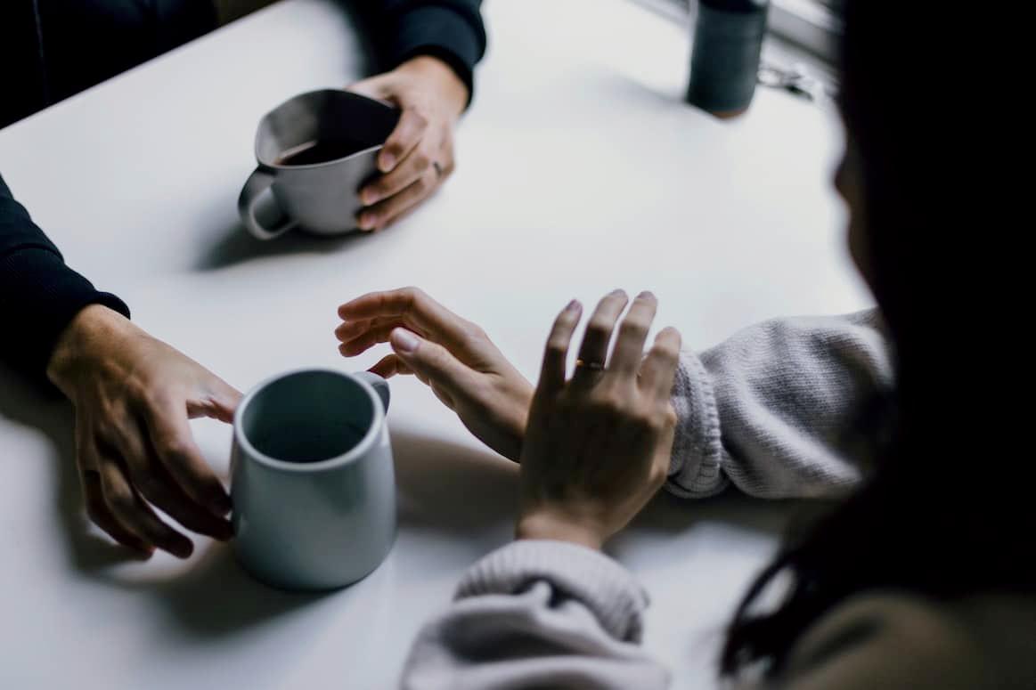 Zwei Personen beim Kaffee-Trinken, die sich unterhalten. Stellvertretend für das Café Klara im Mehrgenerationenhaus.