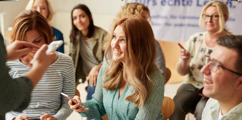 Menschen sitzen in einem Workshop zusammen und diskutieren.