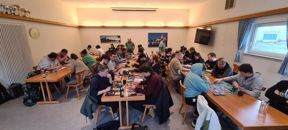 Junge Menschen sitzen an einem Tisch zusammen und bauen an einer Spielelandschaft.